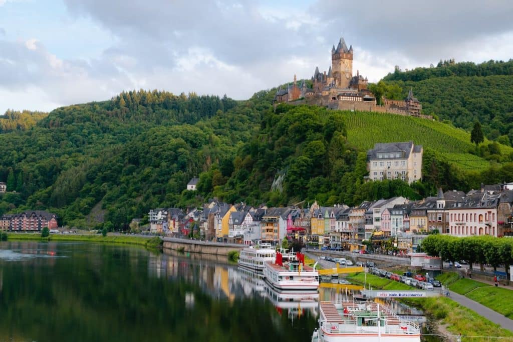 Paisagem de um lago, casas e um castelo no topo da montanha na Alemanha