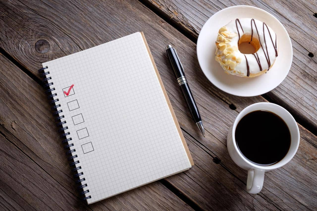 Caderno e caneca de café em cima de uma mesa