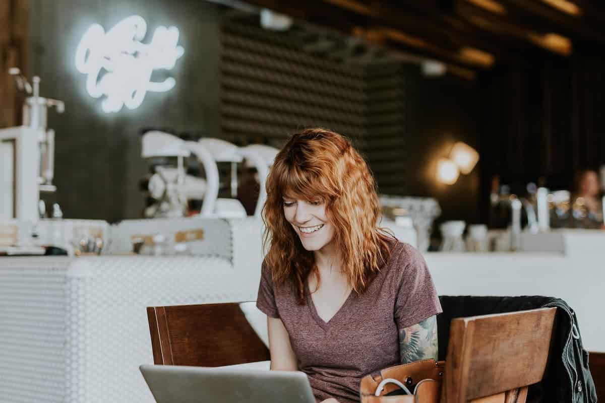 Mulher sentada enquanto usa seu computador