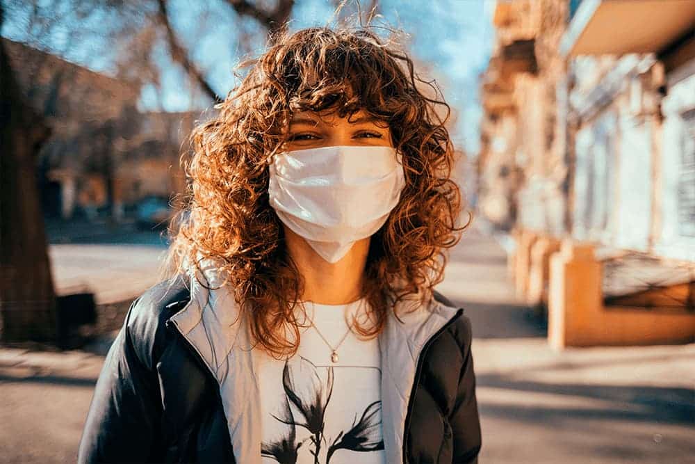 Mulher viajando com máscara cirúrgica de proteção