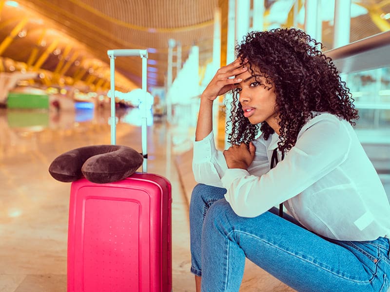 mulher preocupada em aeroporto esperando suas bagagens