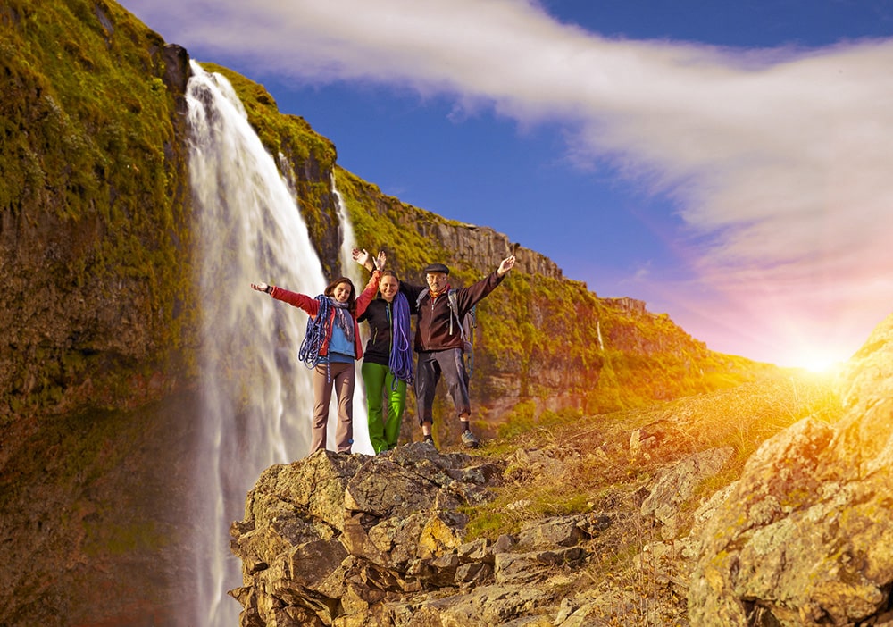 grupo de pessoas posando para uma foto em uma cascata