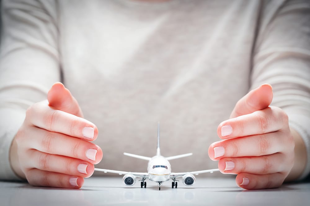 Pessoa com mãos em volta de uma miniatura de avião