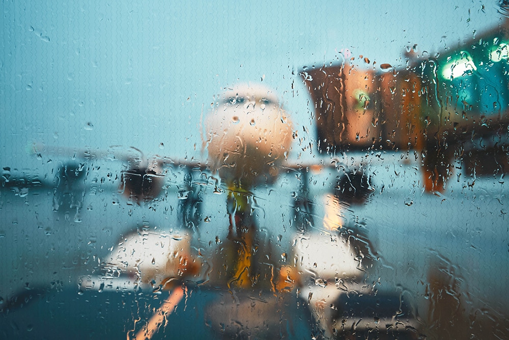 Vidro molhado de chuva e um avião