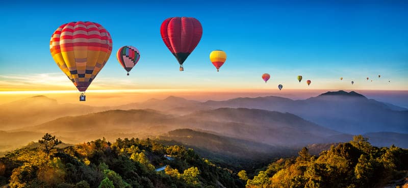Balões voando com paisagem no fundo