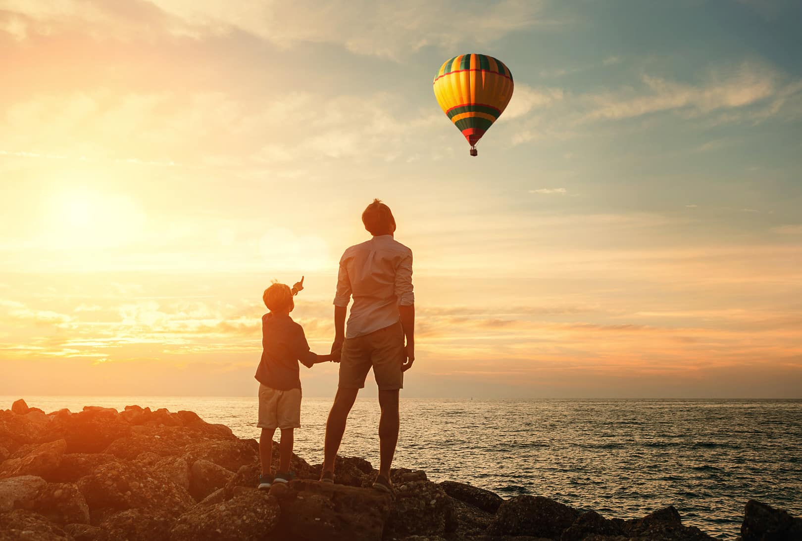 Imagem de um adulto e uma criança observando um balão que sobrevoa o céu