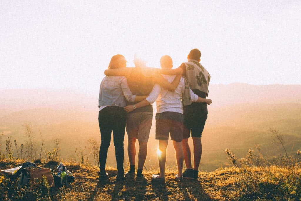 4 pessoas abraçadas fazendo uma viagem em família.