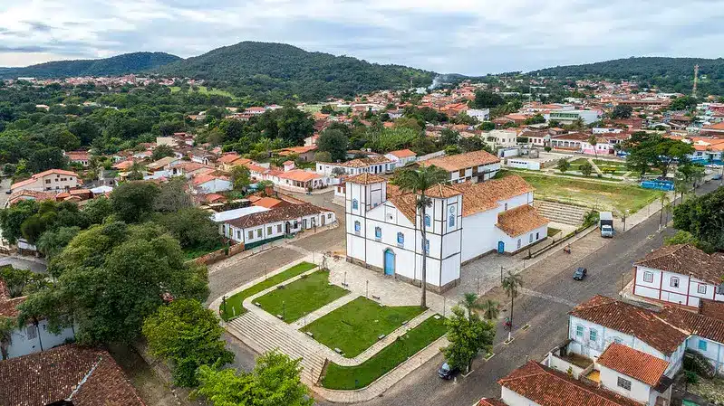 Foto aérea de praça na cidade de Pirenópolis com igreja ao centro e cidade em volta