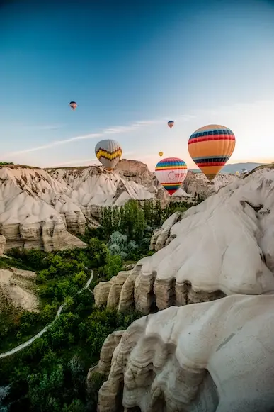 Balões sobrevoando vale entre montanhas na Capadócia na Turquia