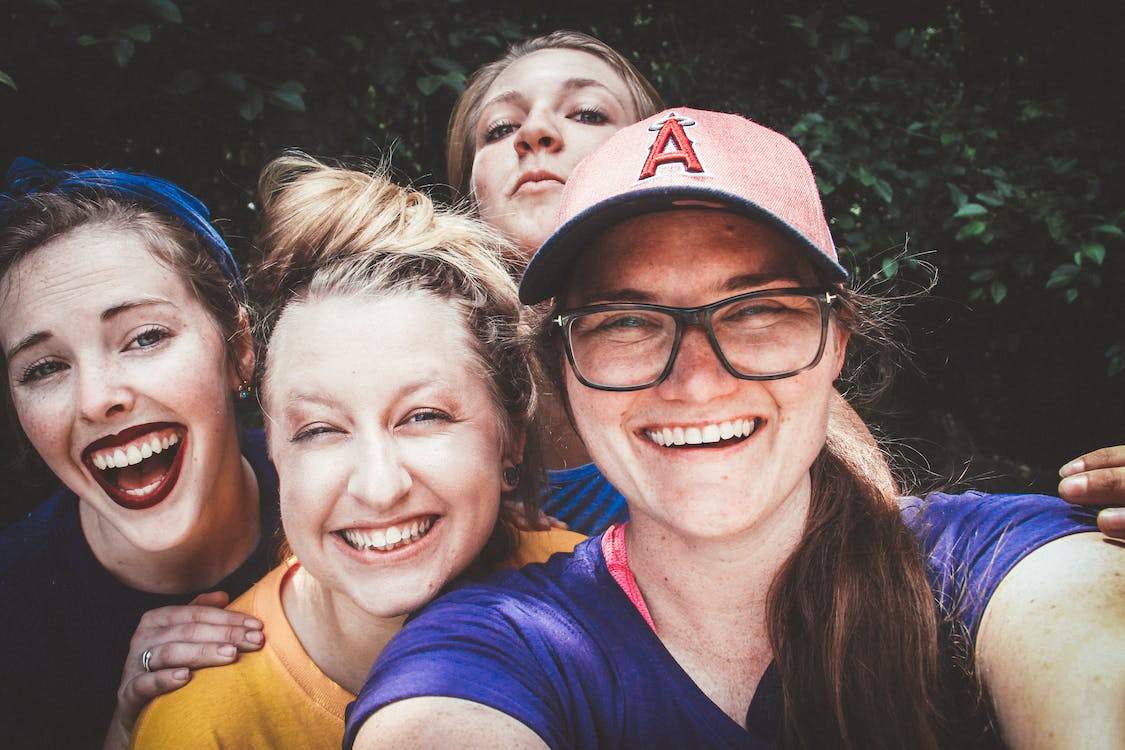 4 meninas adolescentes sorrindo abraçadas