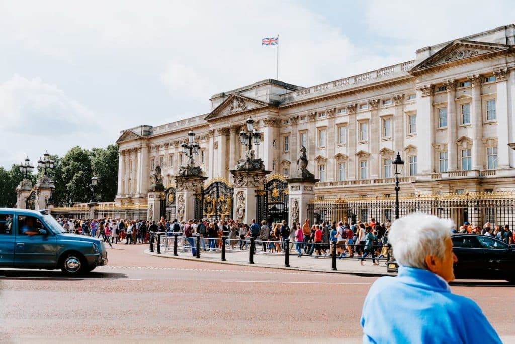 Pessoas andando na frente do Palácio de Buckingham