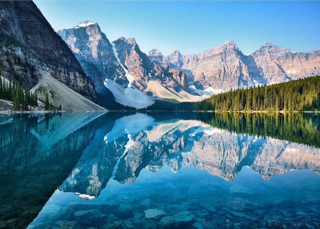 Imagem de cenário de uma montanha e de um lago durante o dia