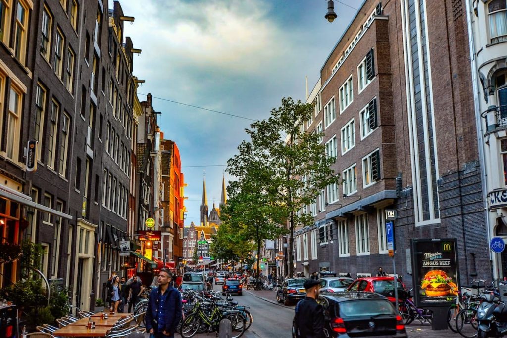 Imagem de uma rua com pessoas andando por Amsterdã
