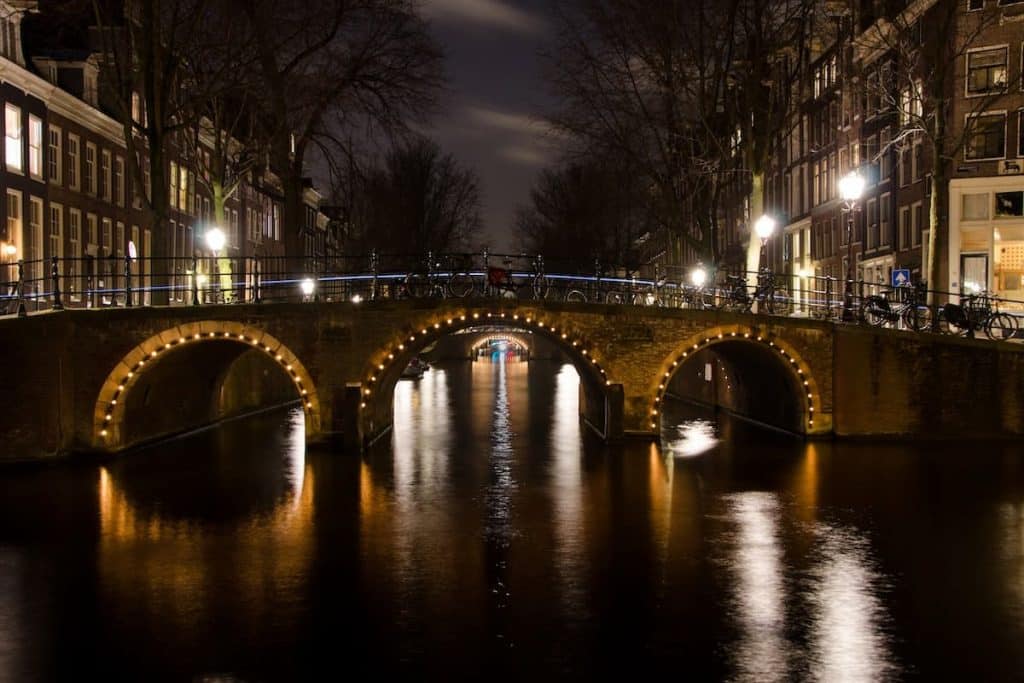 Vista noturna de uma ponte iluminada em um lago na cidade